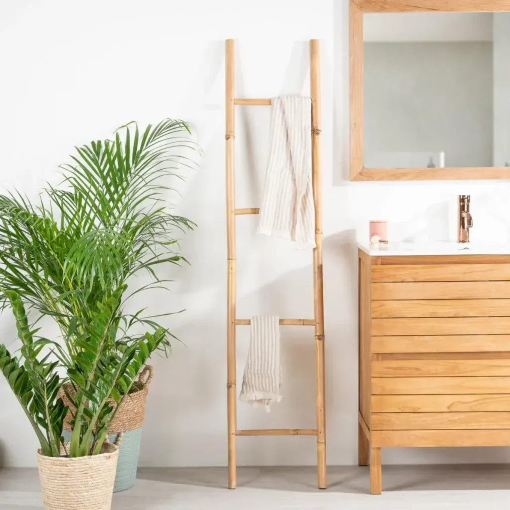 Porte-serviette échelle en bois naturel dans une salle de bain avec plante verte