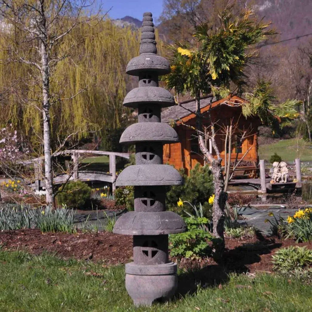 Grande lanterne japonaise pagode zen en pierre de lave dans un jardin paysager