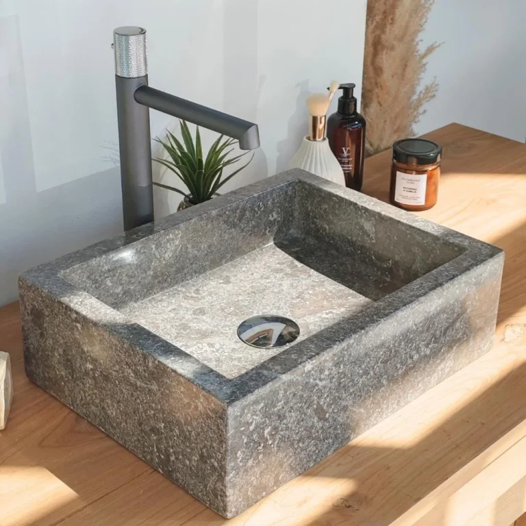Vasque de salle de bain rectangulaire à poser en pierre grise, installée sur un meuble en bois