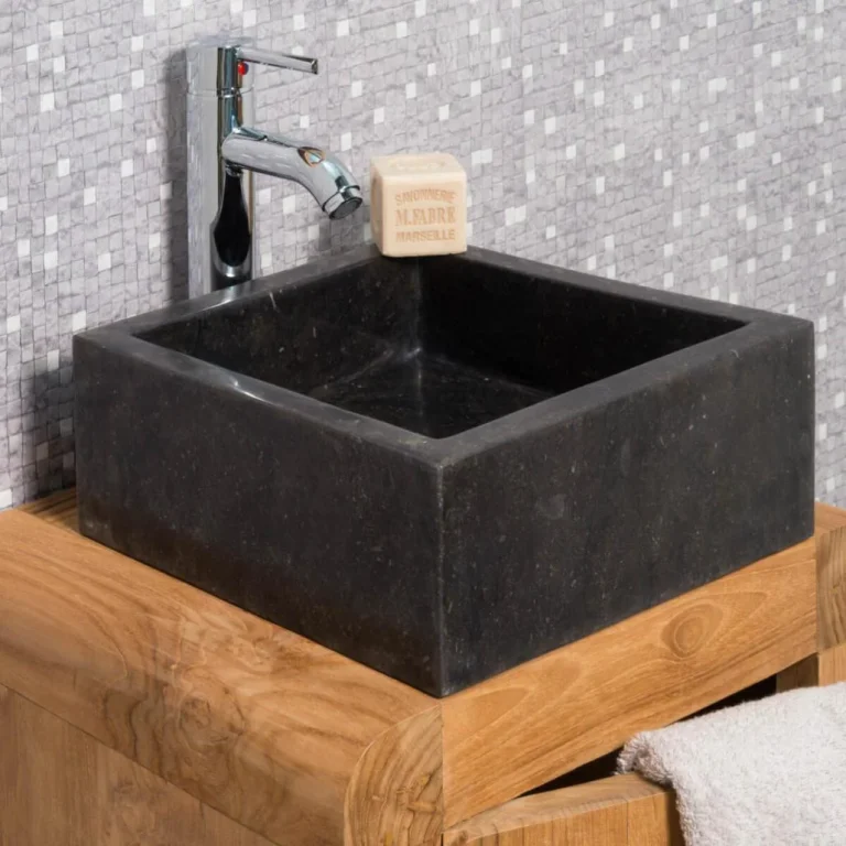 Vasque de salle de bain carrée à poser en marbre noir, installée sur un meuble en bois