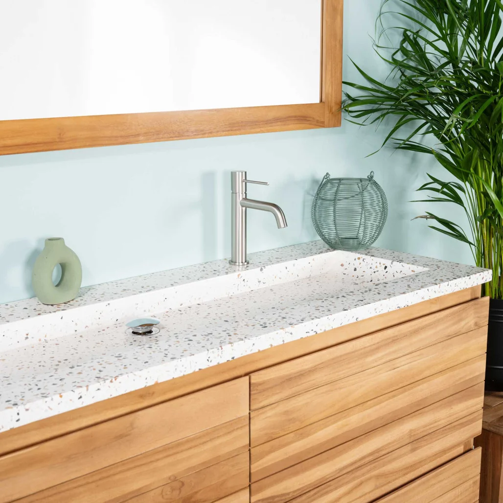 Plan vasque en terrazzo crème avec robinet, installé sur un meuble de salle de bain en bois